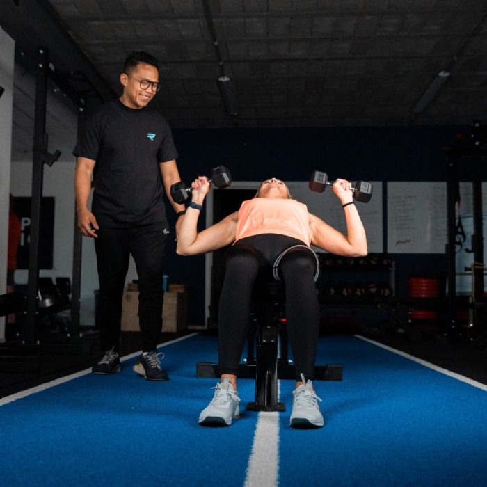 Coach Kristof motiveert tijdens werk met de gewichten